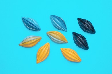 Photo of Tasty chocolate candies on light blue background, flat lay