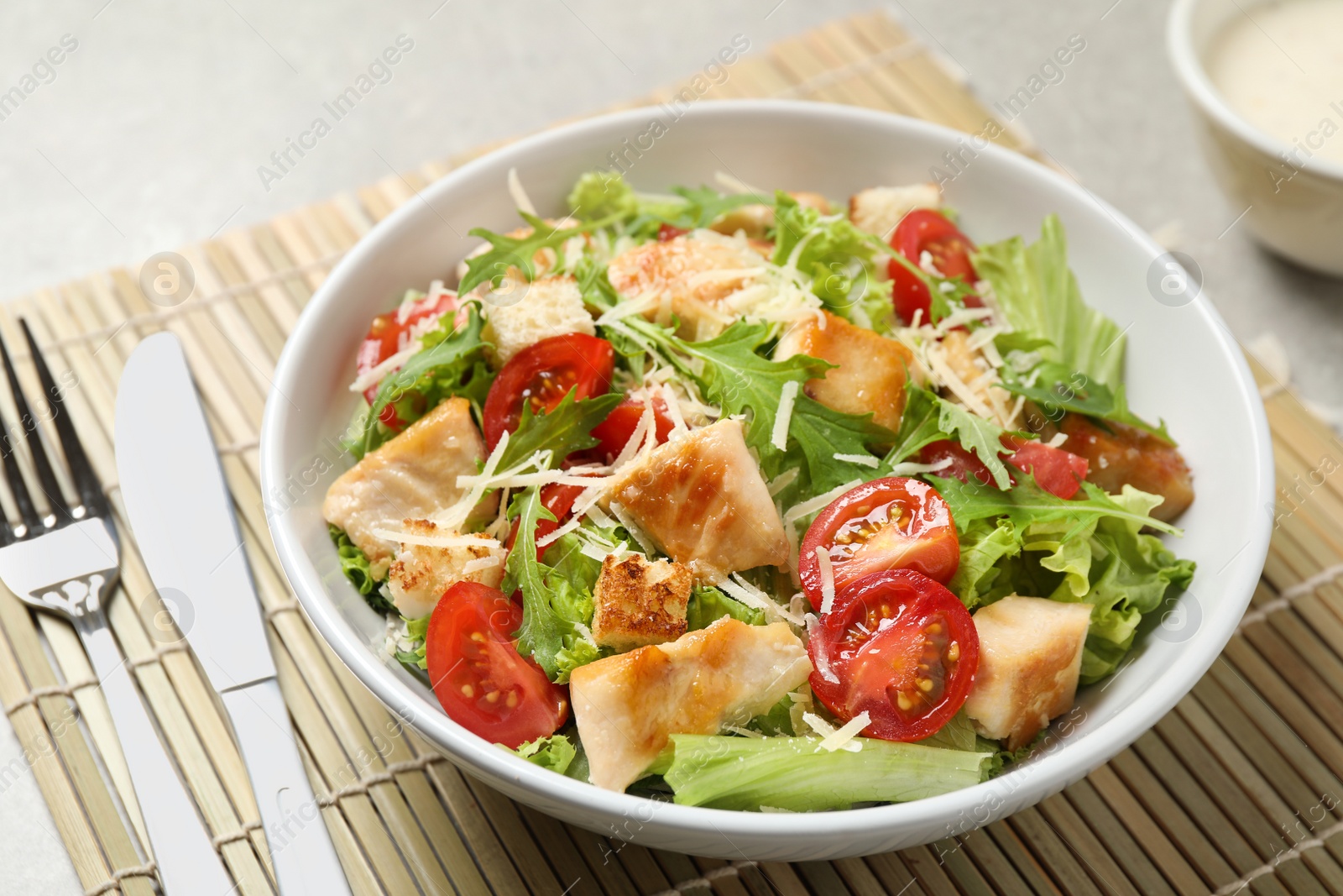 Photo of Delicious fresh Caesar salad in bowl on table