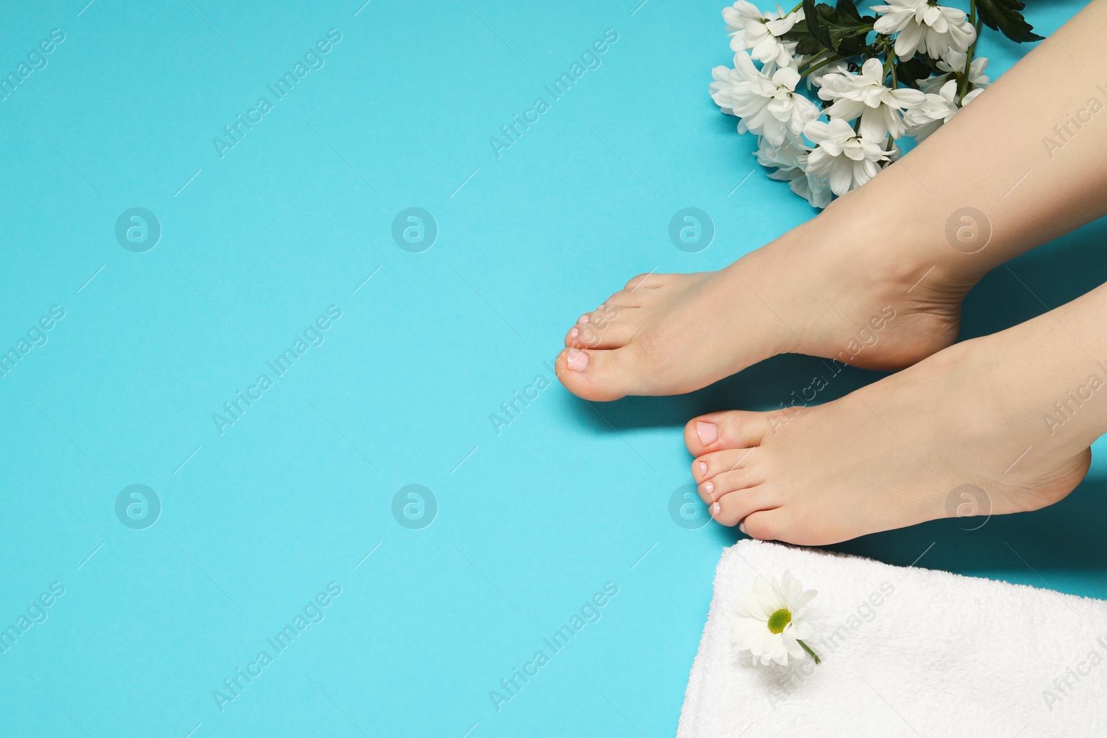 Photo of Woman with neat toenails after pedicure procedure on light blue background, closeup. Space for text
