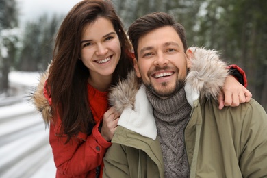 Photo of Couple in warm clothes outdoors. Winter vacation