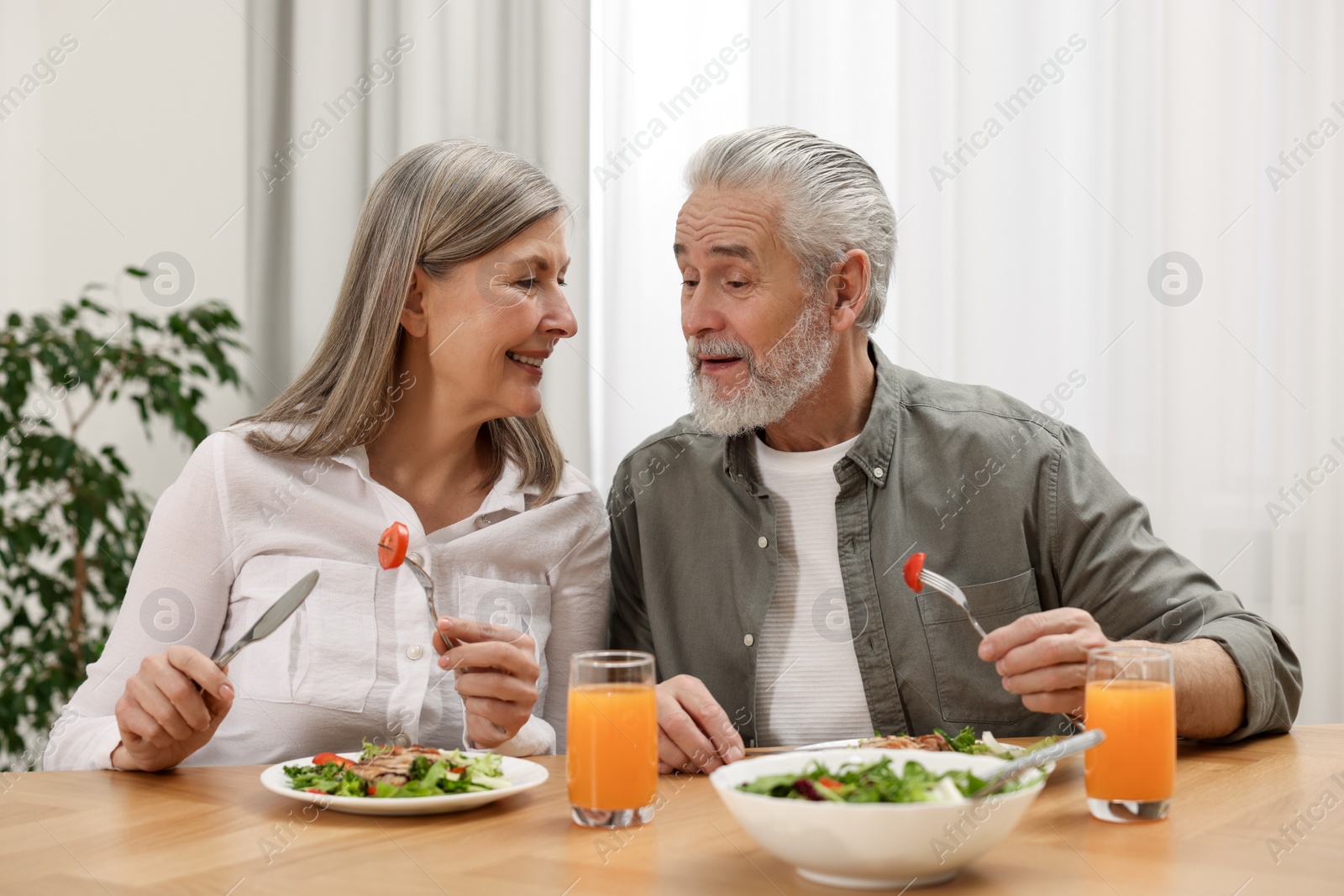 Photo of Happy senior couple having dinner at home