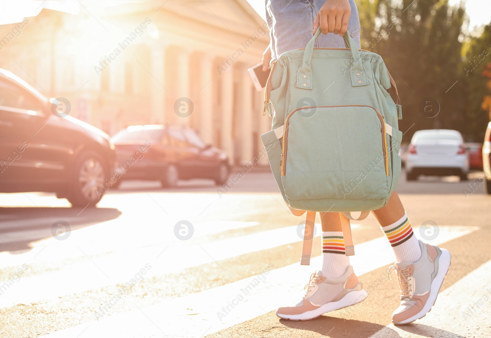 Photo of Young woman with stylish turquoise bag on city street, closeup