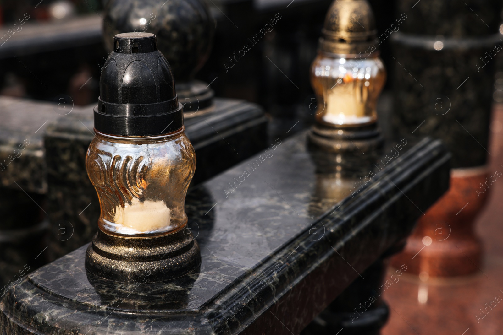 Photo of Grave lantern with candle on granite surface at cemetery, space for text