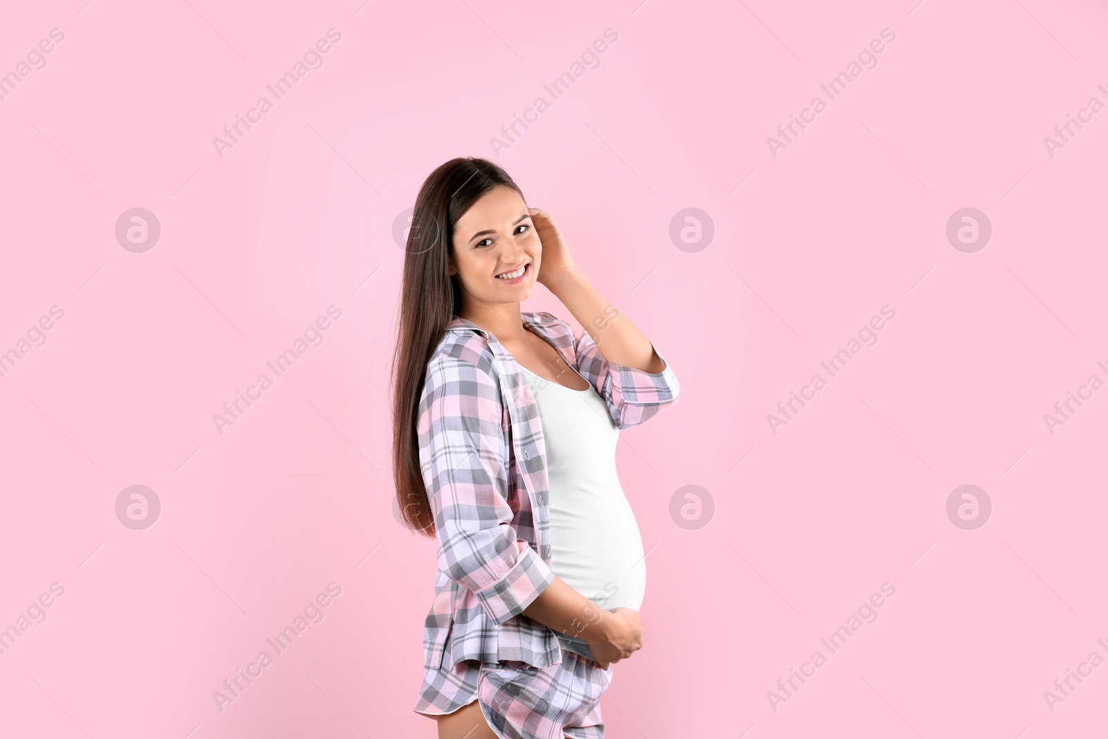 Photo of Young beautiful pregnant woman against color background