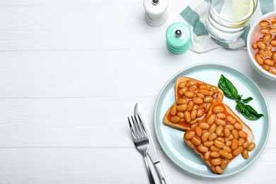 Photo of Toasts with delicious canned beans on white wooden table, flat lay. Space for text