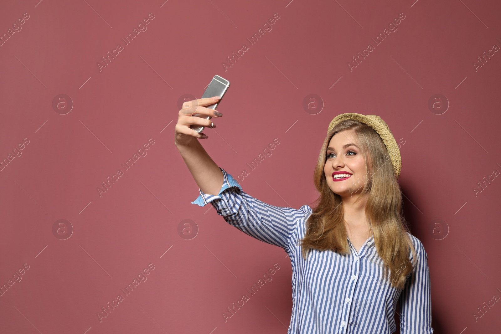 Photo of Attractive young woman taking selfie on color background