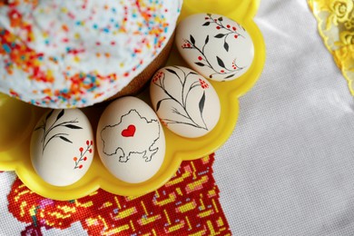 Easter kulich and decorated eggs on cloth, top view. Space for text