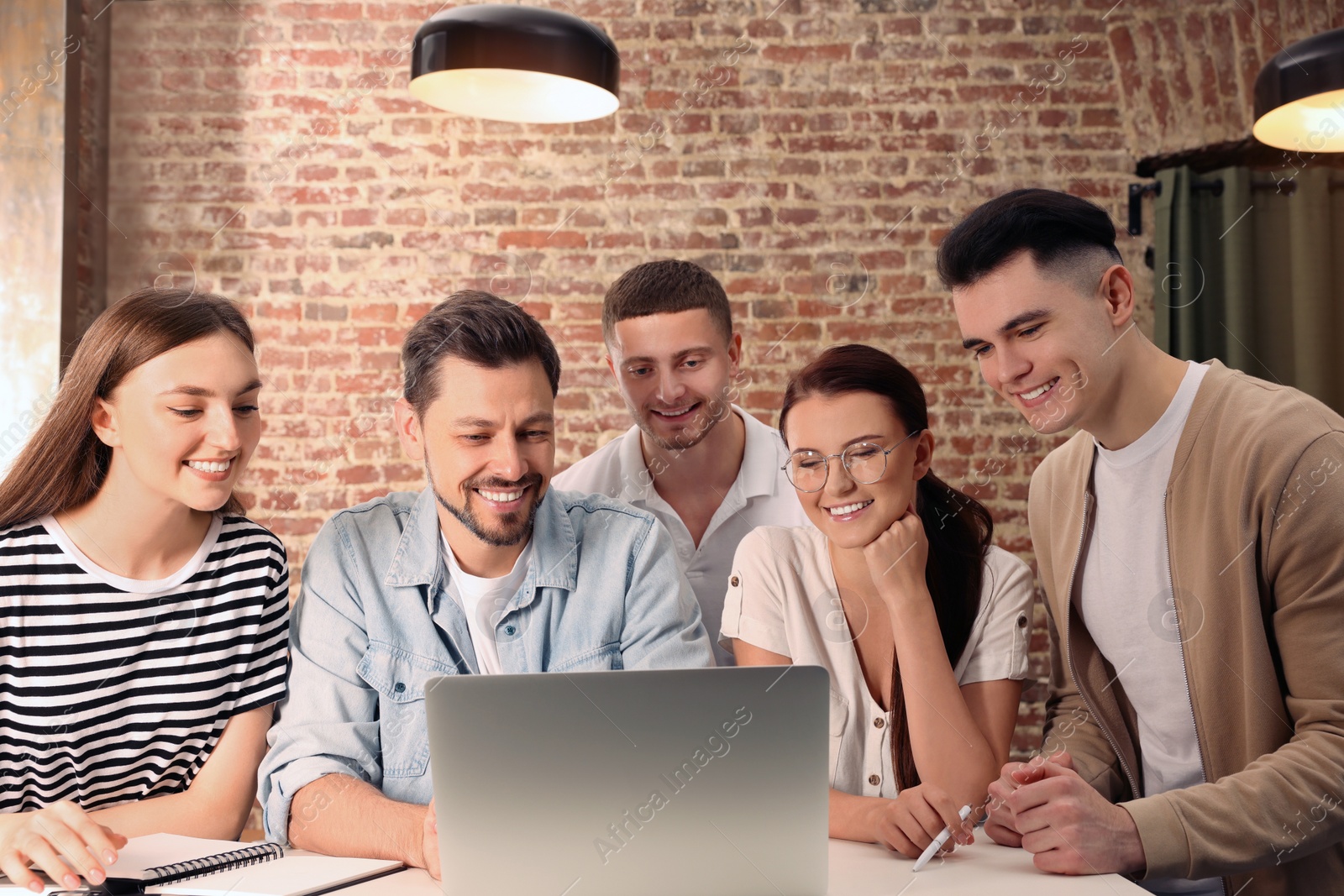 Photo of Team of employees working together in office