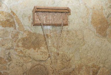 Waterfall shower with running water in spa center