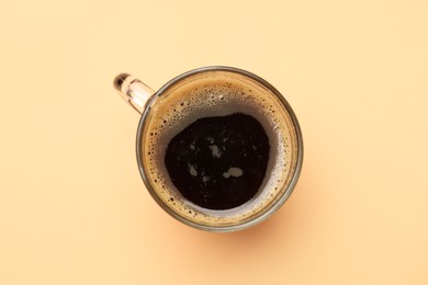 Photo of Fresh coffee in cup on beige background, top view