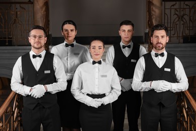 Photo of Group of trainees wearing formal clothes in hotel. Professional butler courses