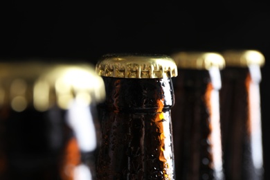 Photo of Many bottles of beer on dark background, closeup view