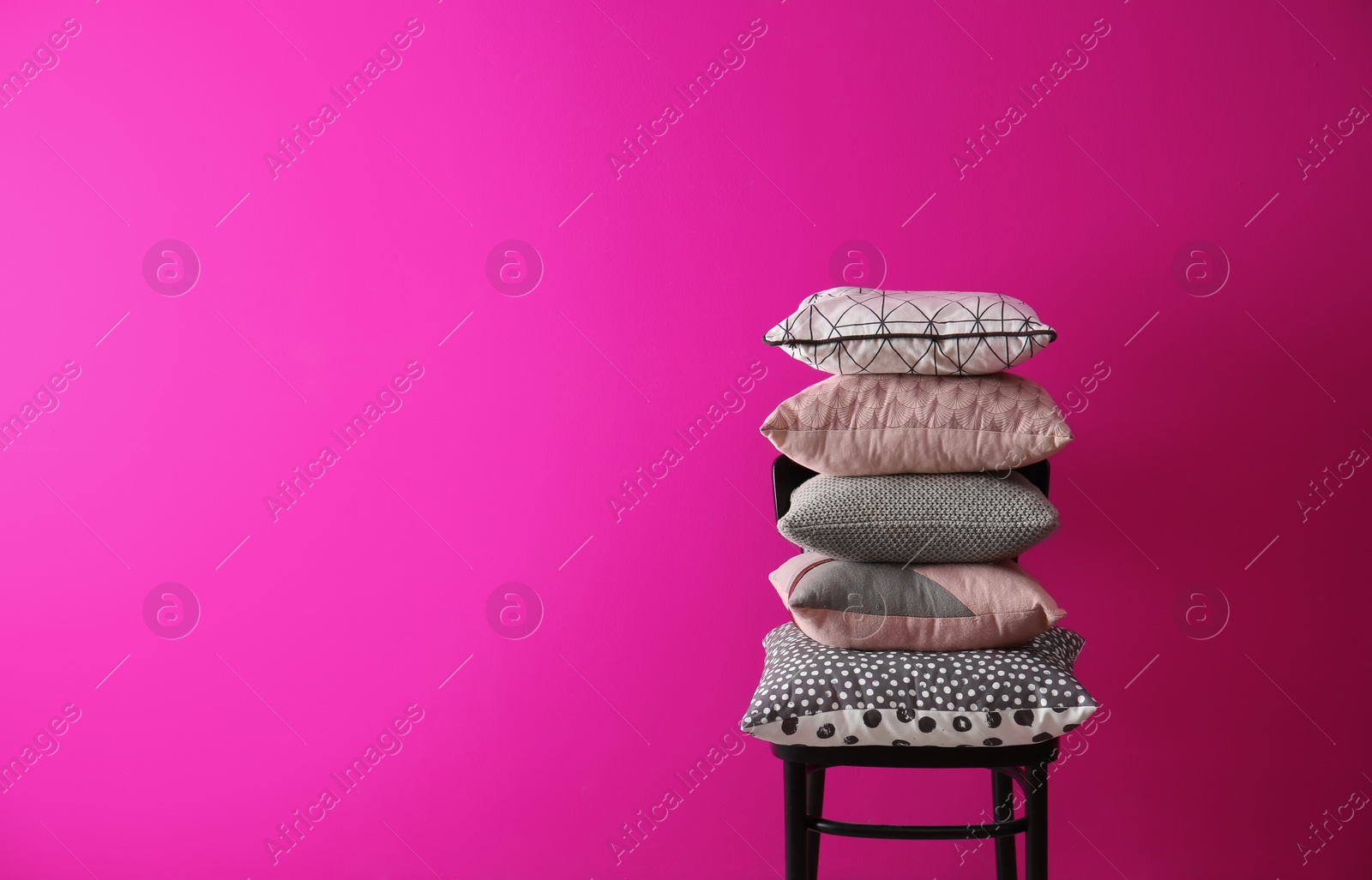 Photo of Chair with many different pillows and space for text on color background