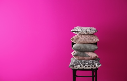 Photo of Chair with many different pillows and space for text on color background