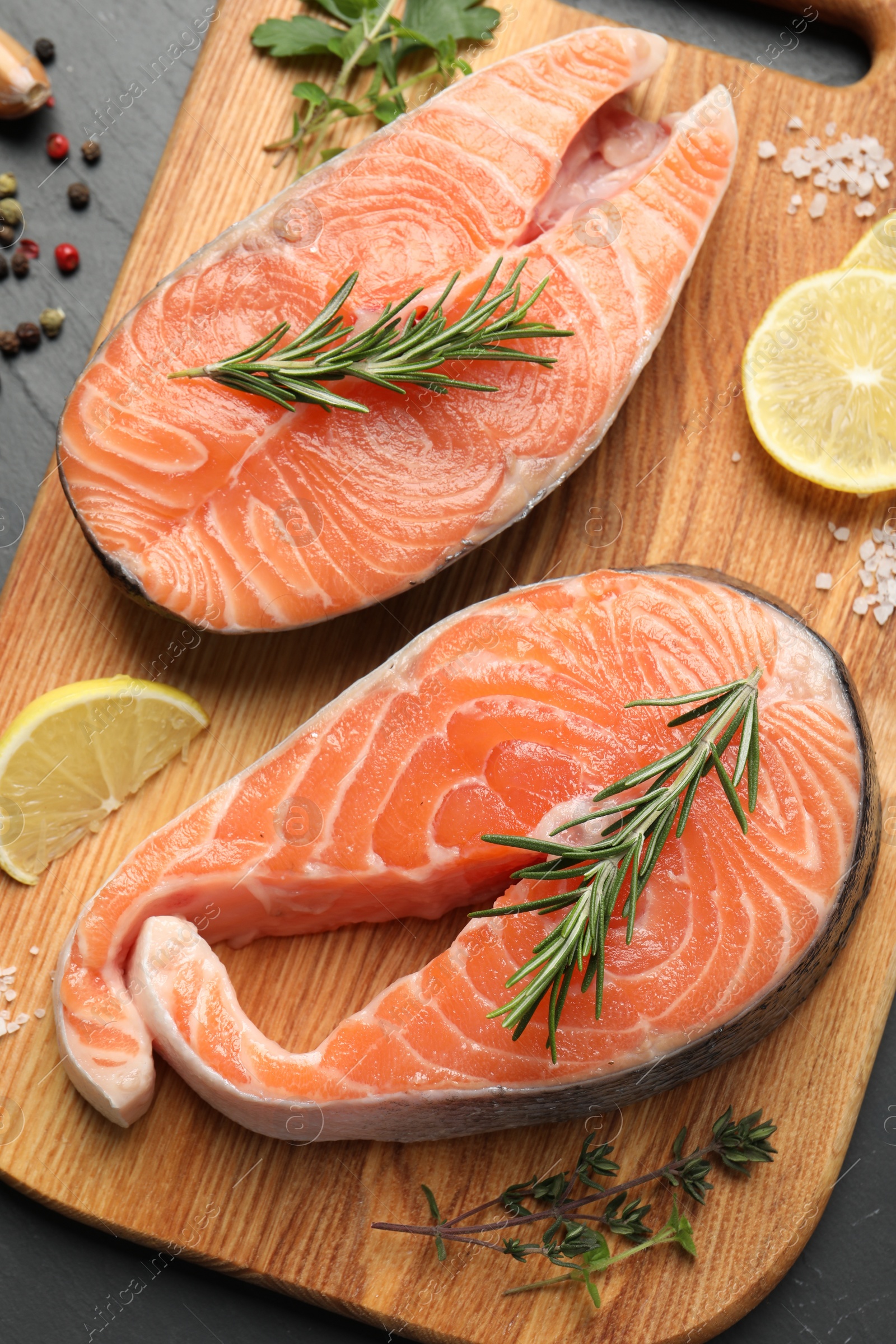 Photo of Fresh salmon and ingredients for marinade on black table, flat lay