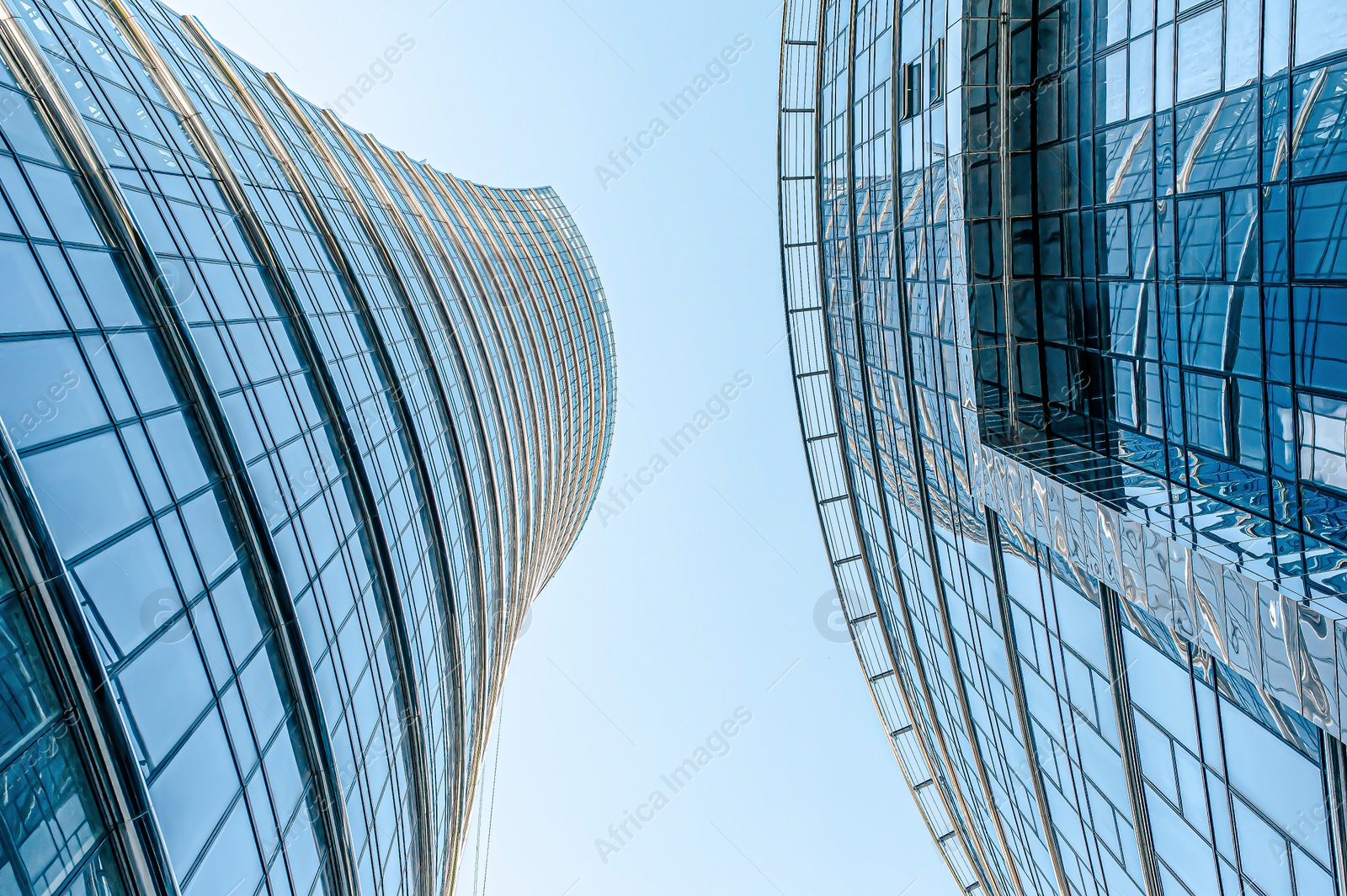 Photo of Stylish buildings with many windows under cloudy sky, low angle view