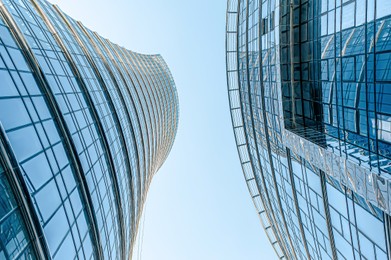 Stylish buildings with many windows under cloudy sky, low angle view