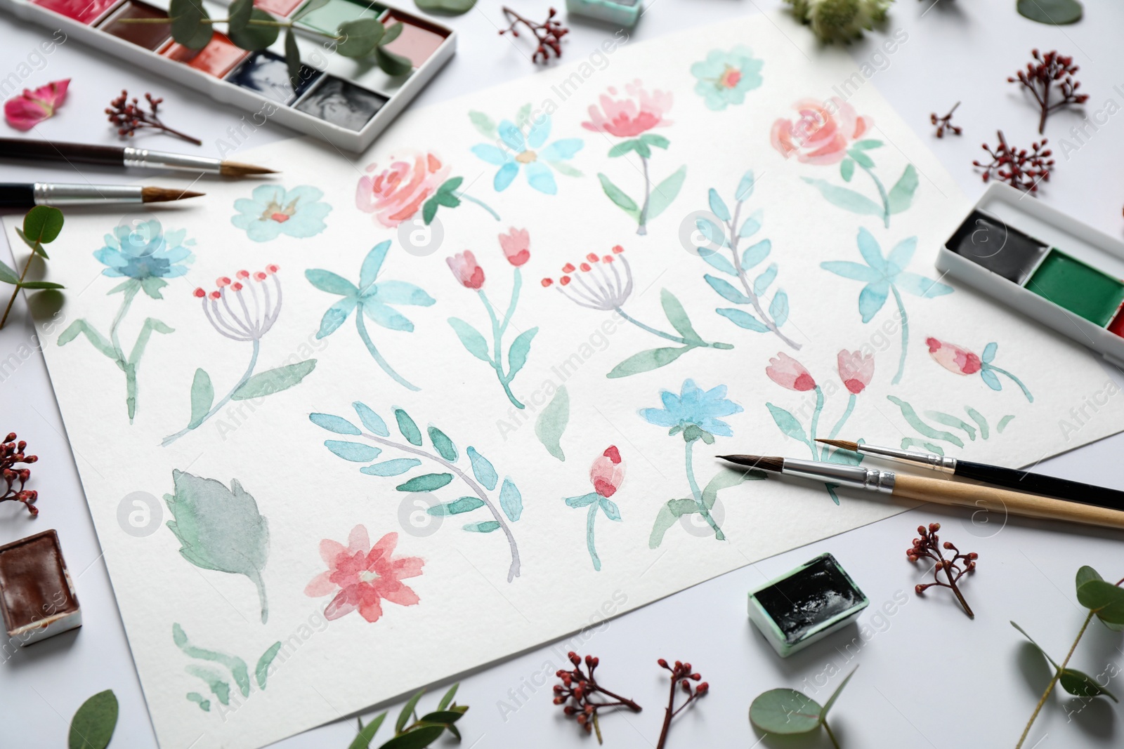 Photo of Composition with watercolor paints and floral picture on white background