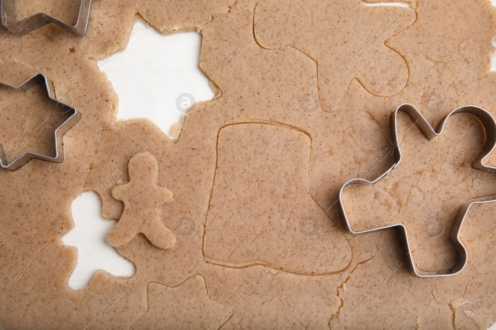 Photo of Homemade Christmas biscuits. Raw dough and cookie cutters on table, flat lay