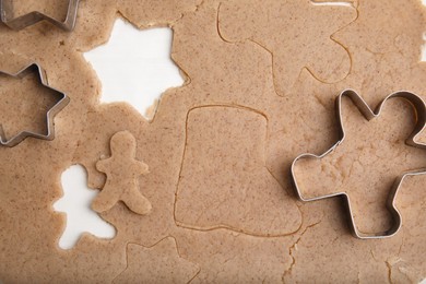 Photo of Homemade Christmas biscuits. Raw dough and cookie cutters on table, flat lay