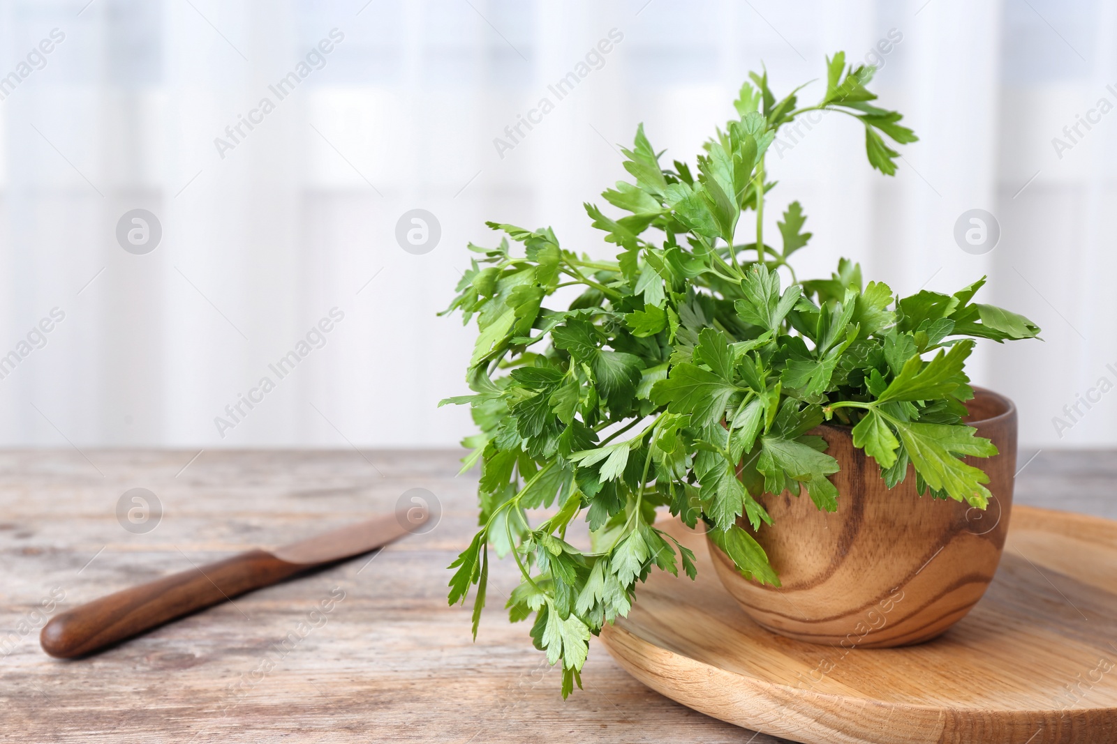 Photo of Bowl with fresh green parsley on table. Space for text