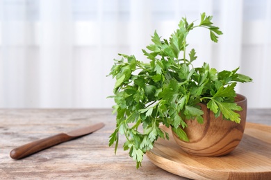 Bowl with fresh green parsley on table. Space for text