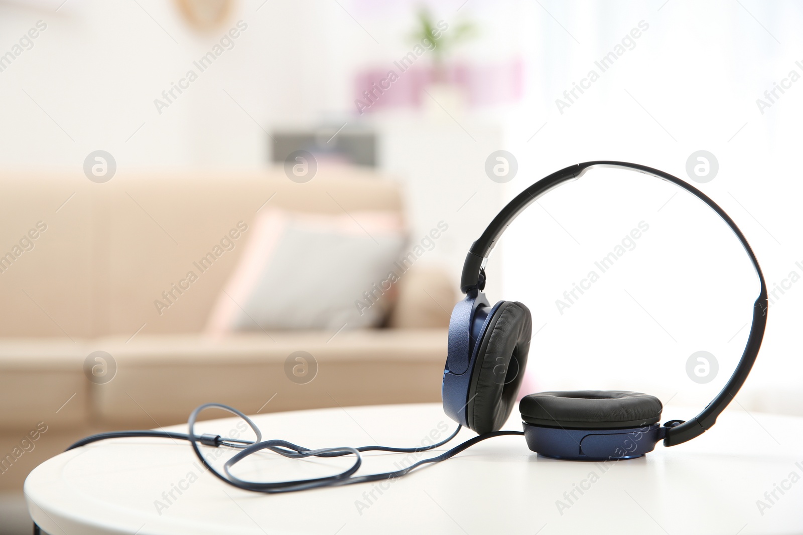 Photo of Stylish headphones on table indoors. Space for text