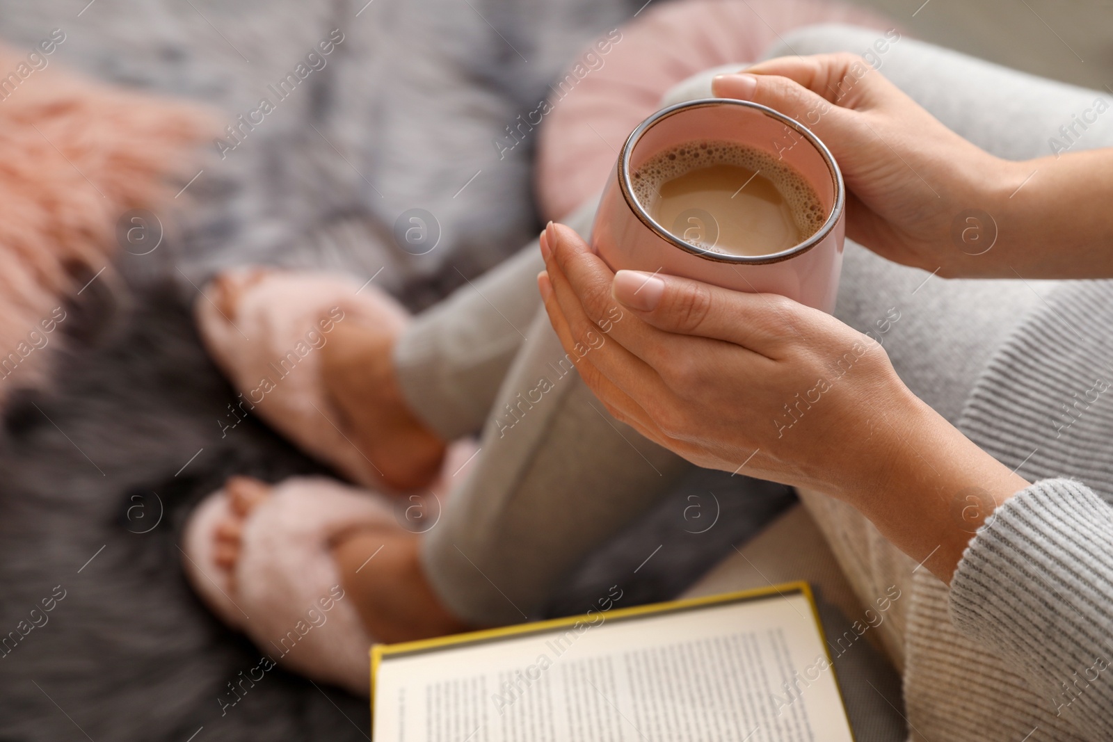 Photo of Woman with cup of hot coffee resting at home, above view