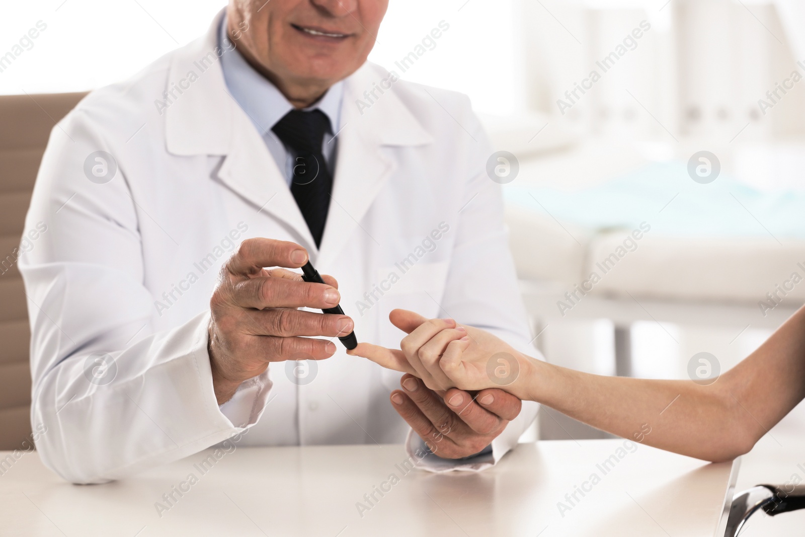 Photo of Doctor taking patient's blood sample with lancet pen in hospital, closeup. Diabetes control