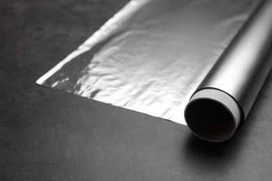 Photo of Roll of foil paper on grey table, closeup