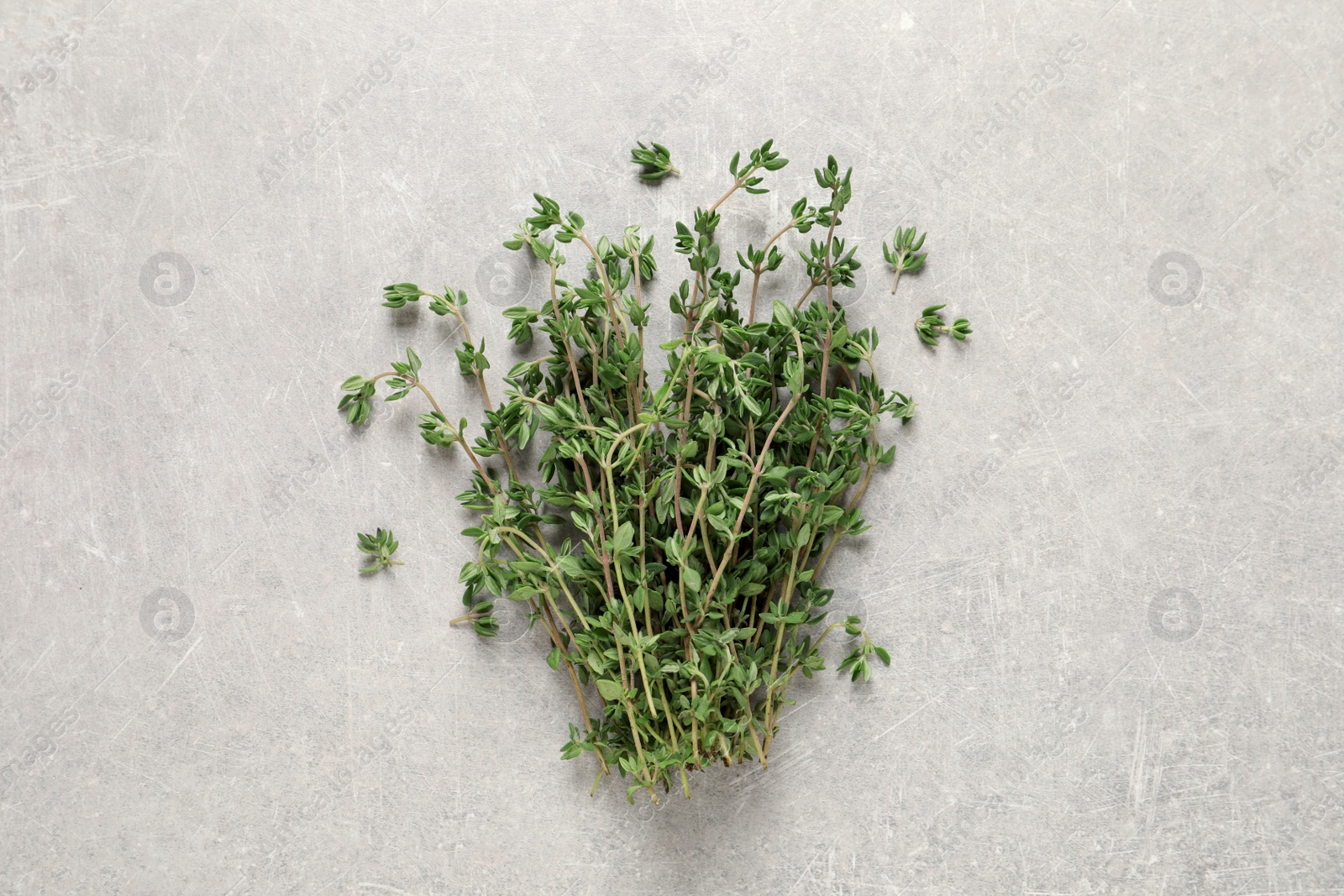 Photo of Bunch of aromatic thyme on light grey table, top view