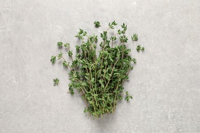 Bunch of aromatic thyme on light grey table, top view