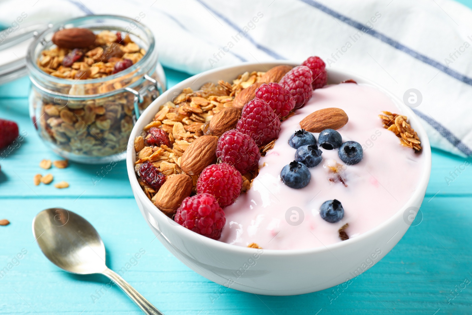 Photo of Tasty homemade granola served on blue wooden table. Healthy breakfast