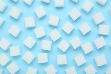 White sugar cubes on light blue background, top view