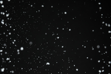 White snow falling down on black background