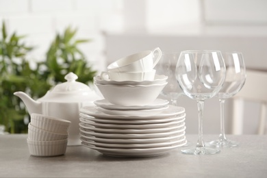 Set of clean dishes on table against blurred background