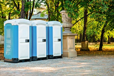 Photo of Public toilet cabins on street near trees