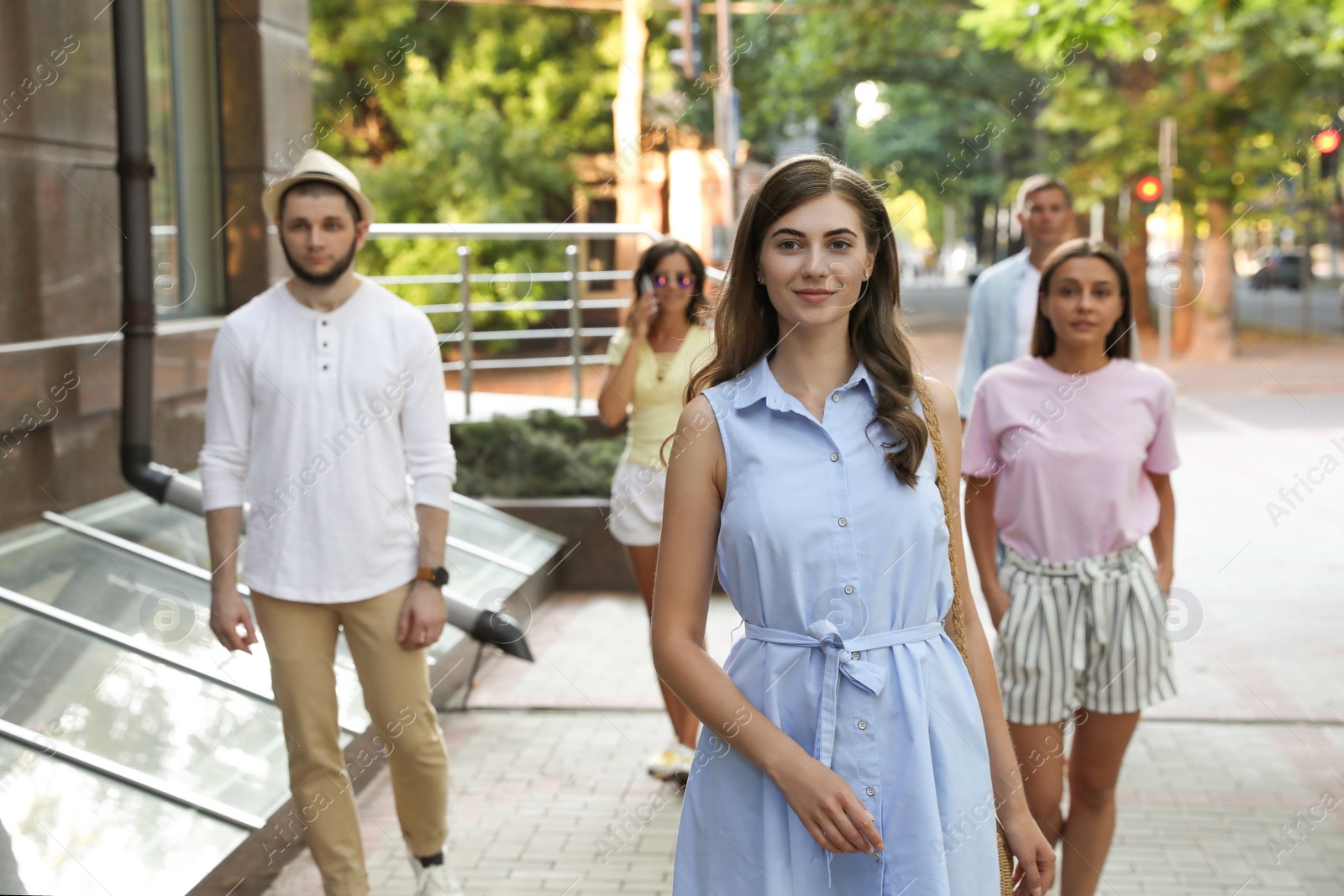 Photo of Different people walking on modern city street