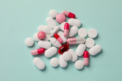 Photo of Many different pills on mint background, flat lay
