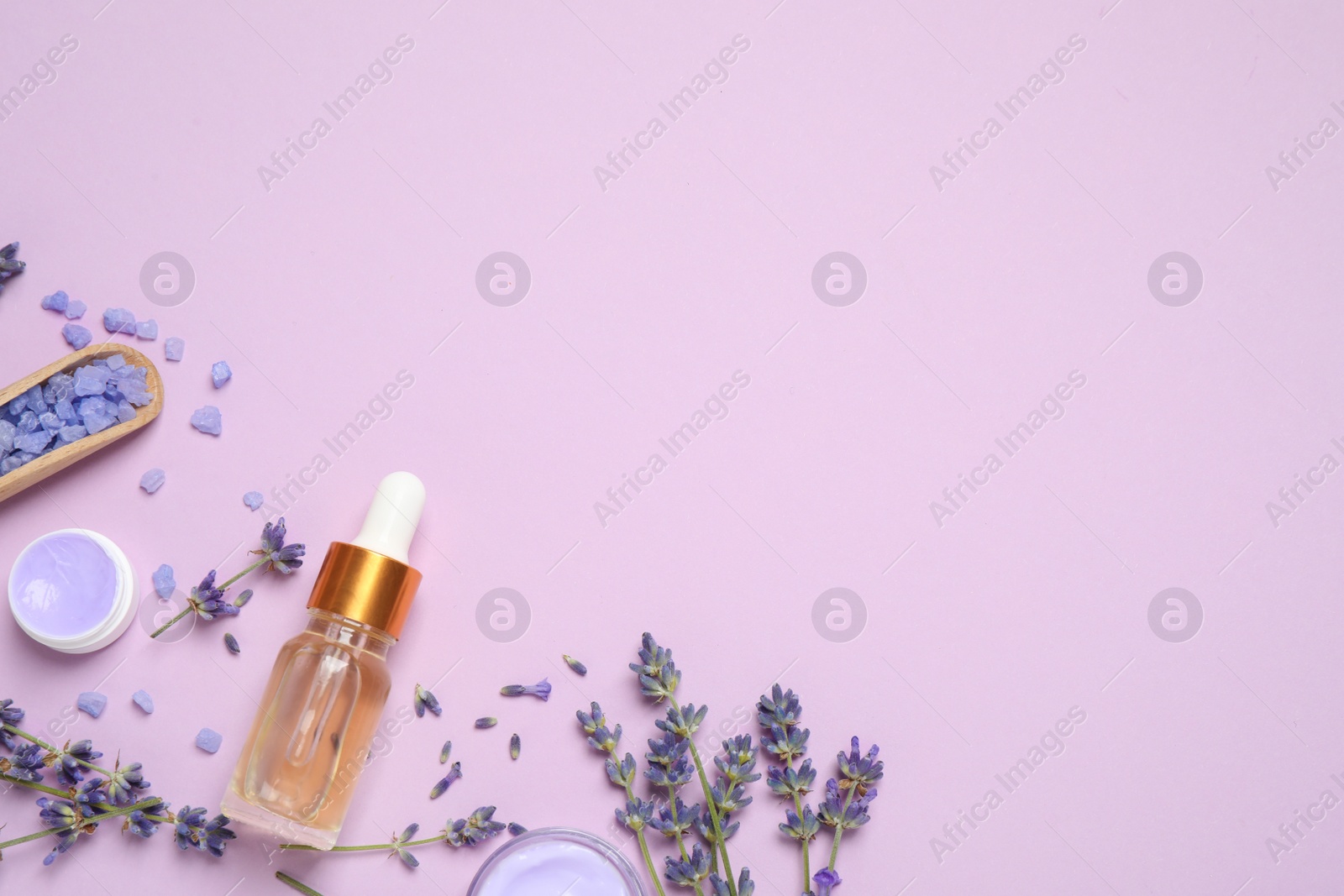 Photo of Flat lay composition with lavender flowers and natural cosmetic products on pink background. Space for text