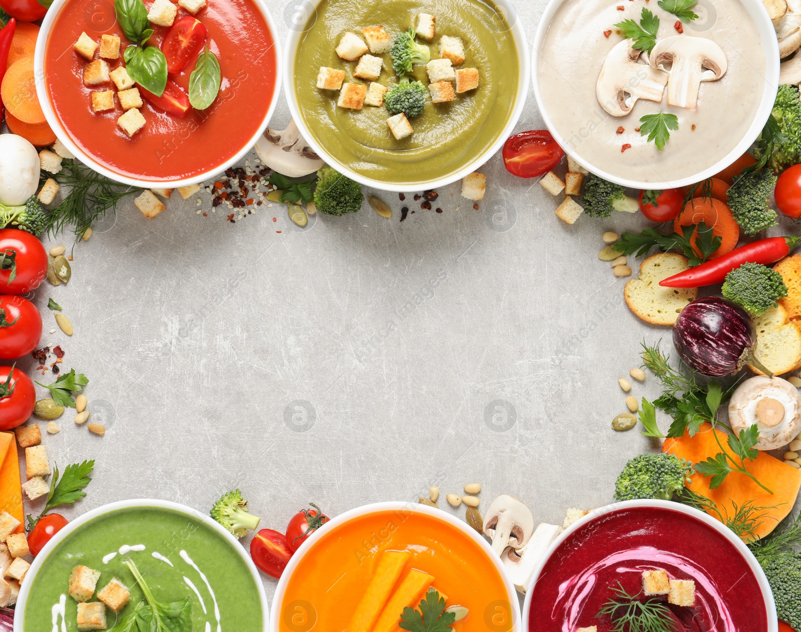 Photo of Various cream soups, ingredients and space for text on grey background, flat lay. Healthy food