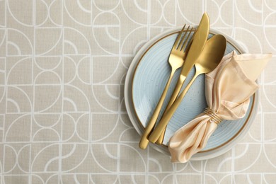 Photo of Stylish setting with cutlery, plates and napkin on table, top view. Space for text