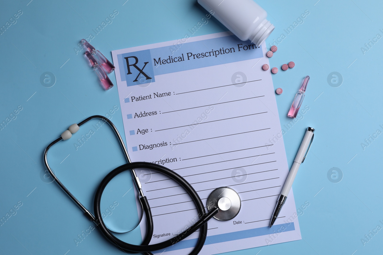 Photo of Medical prescription form, stethoscope, ampoules and pills on light blue background