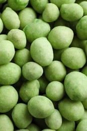 Photo of Tasty wasabi coated peanuts as background, top view