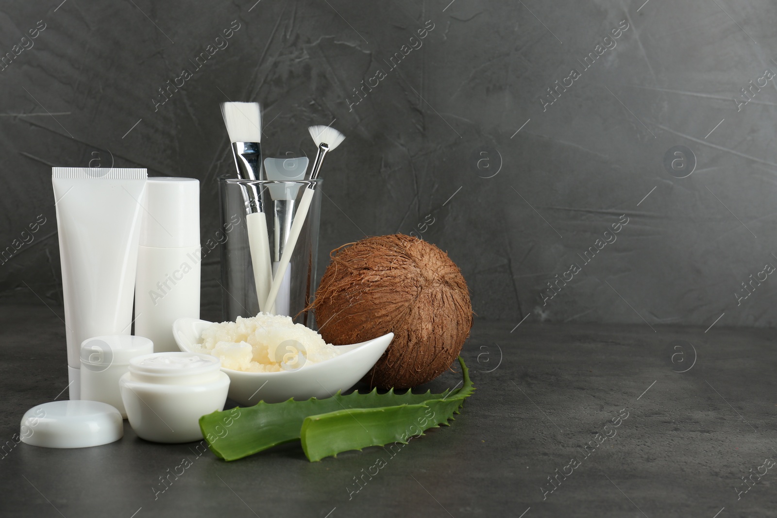 Photo of Homemade cosmetic products, tools and fresh ingredients on black table. Space for text