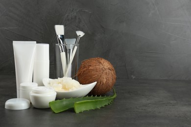 Photo of Homemade cosmetic products, tools and fresh ingredients on black table. Space for text