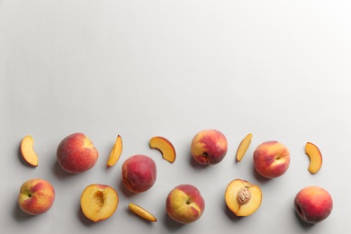 Photo of Flat lay composition with fresh peaches on grey background. Space for text