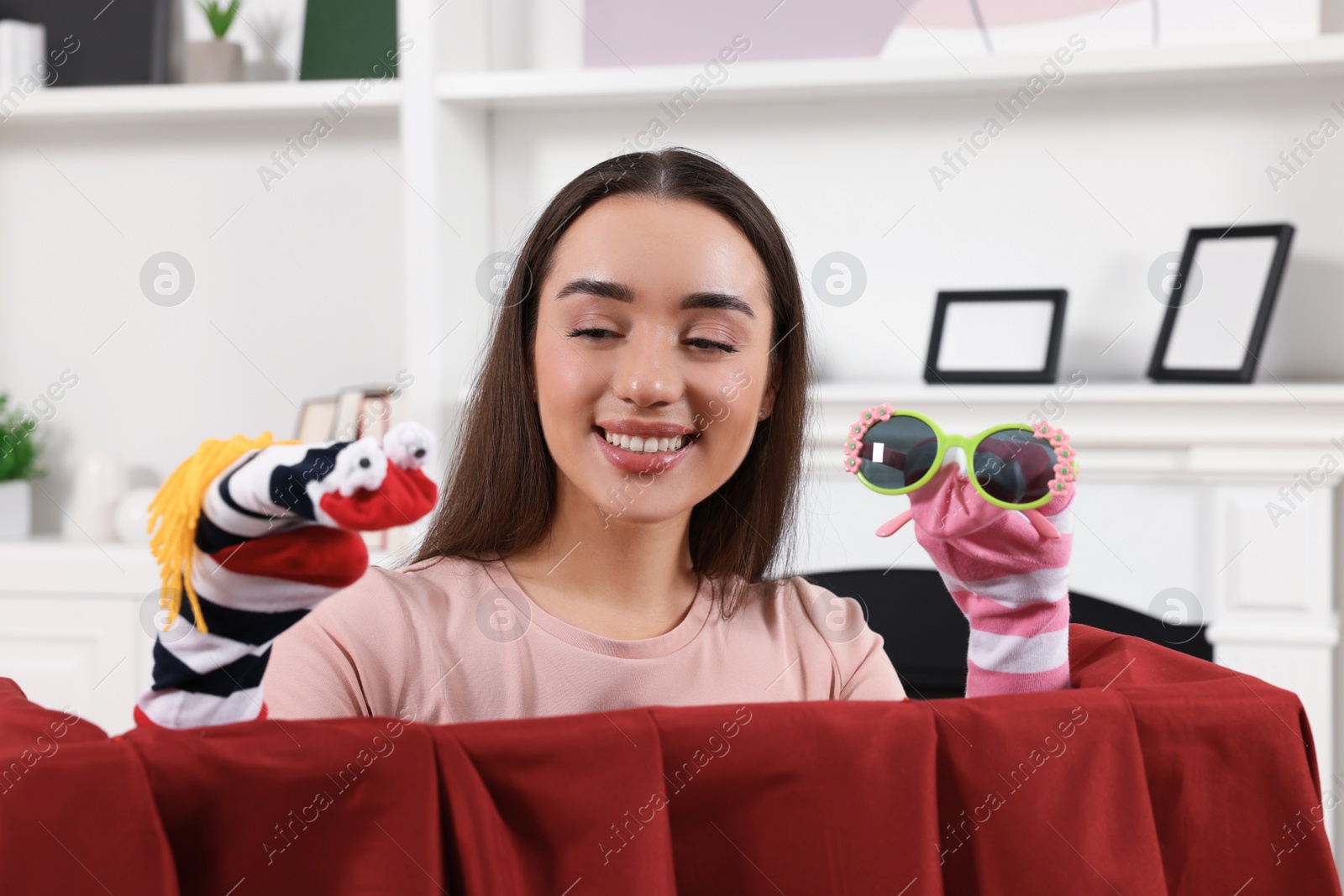 Photo of Happy woman performing puppet show at home