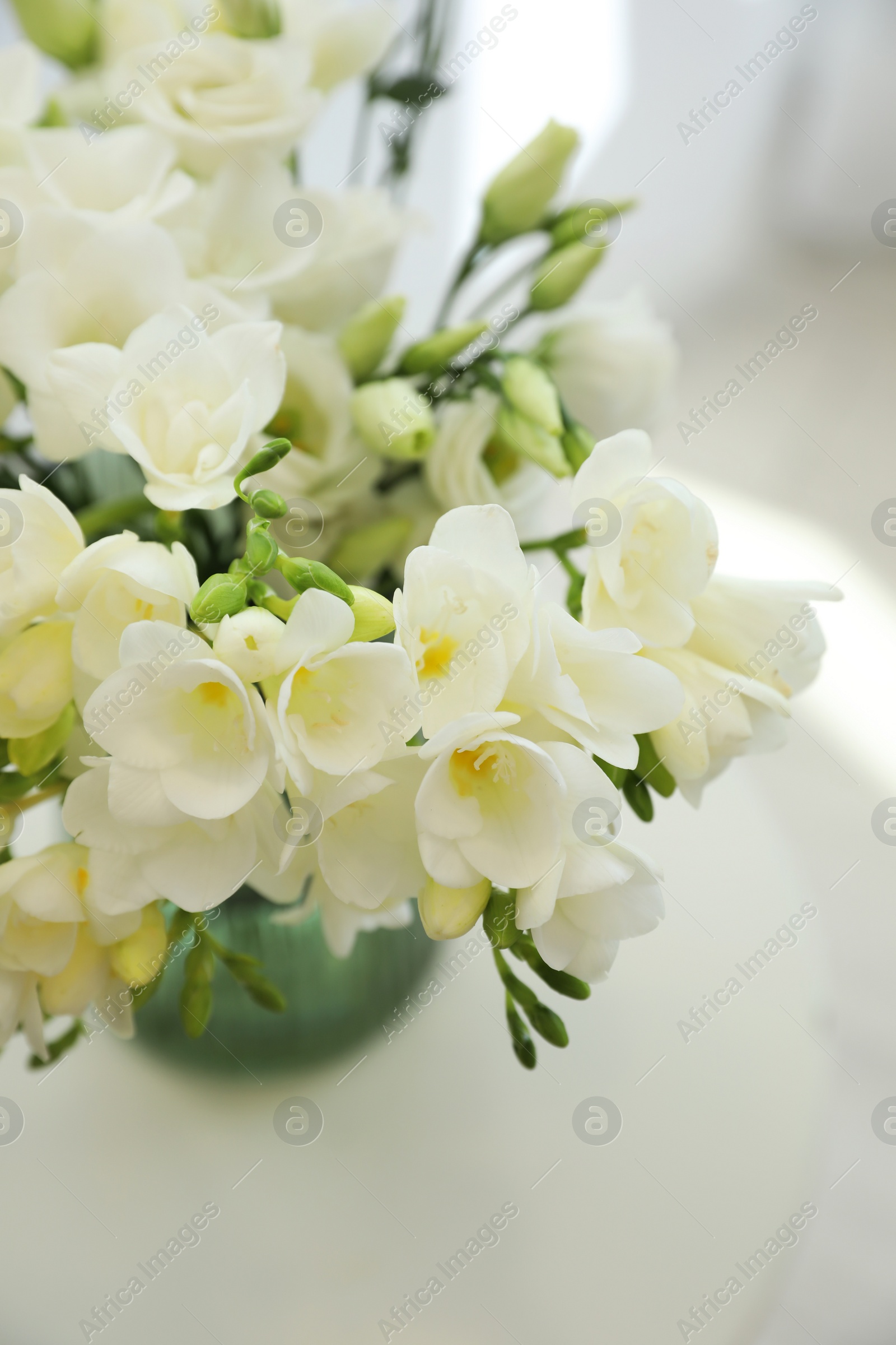 Photo of Beautiful bouquet with white freesia flowers on table indoors, above view