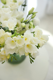 Photo of Beautiful bouquet with white freesia flowers on table indoors, above view